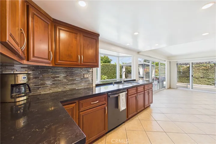 Remodeled kitchen with wood cabinets, stone countertops, and matching appliances