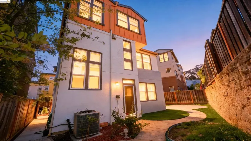 Multi-level exterior with white stucco and orange paneling accents