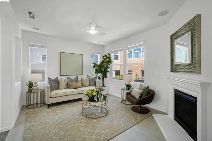 Living area featuring a white fireplace with a classic mantel, multiple large windows, and recessed lighting