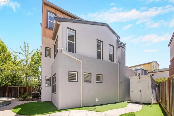 Modern multi-story exterior with light gray stucco and dark trim accents