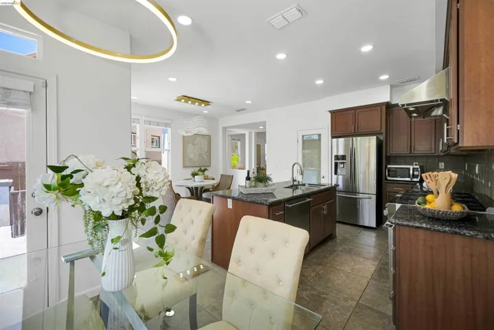 Gourmet kitchen featuring dark wood cabinetry, granite countertops, and stainless steel appliances