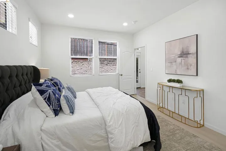 Spacious room featuring light-colored flooring, recessed lighting, and bright white walls