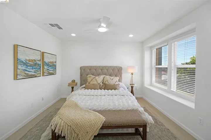 Bright interior space featuring a multi-pane window, recessed lighting, a ceiling fan, and wood-finish flooring