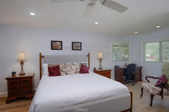 Spacious primary suite with ceiling fan and recessed lighting