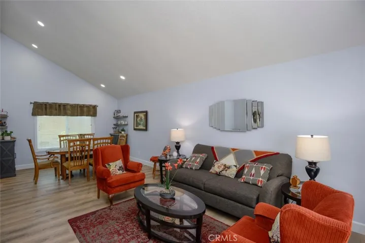 Living room and formal dining area with cathedral ceiling and recessed lighting
