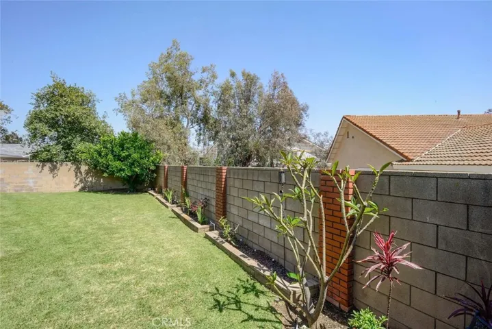 Beautifully landscaped yard with maintenance free block fencing with brick accents
