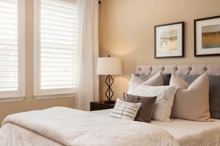 Designer touches and abundant natural light create a warm and inviting bedroom retreat.