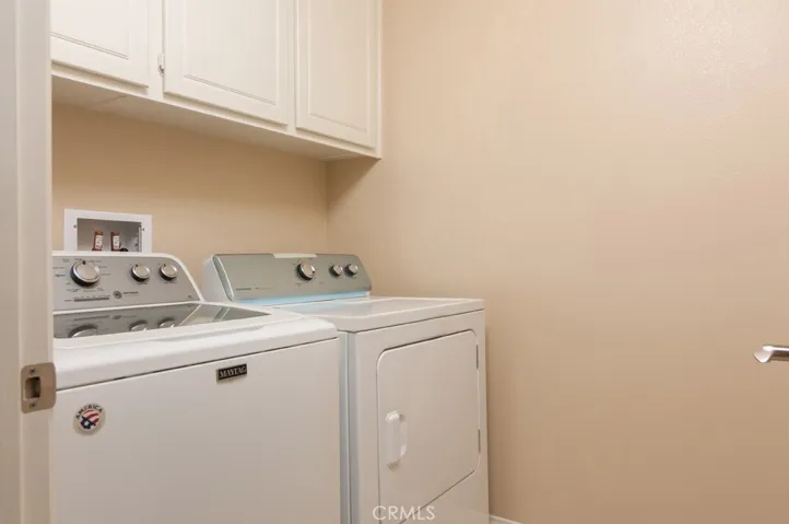 Convenient indoor laundry room with full-size washer and dryer adds ease to everyday living.