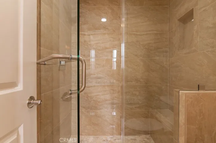 Oversized walk-in shower with elegant tile detailing offers a luxurious spa-like experience.