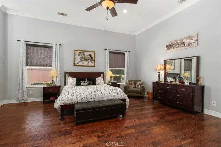 Primary suite with hardwood flooring, ceiling fan, dual sided fireplace, retreat, private entrance, walk-in closet and luxury primary bath