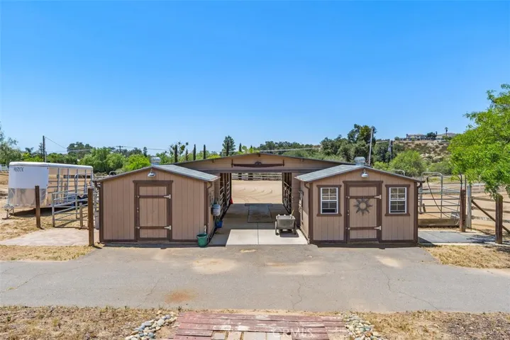 4 Stall Barn with lights, 2 sliding barn doors, cross ties, wash rack, tack room, feed room & hitching posts