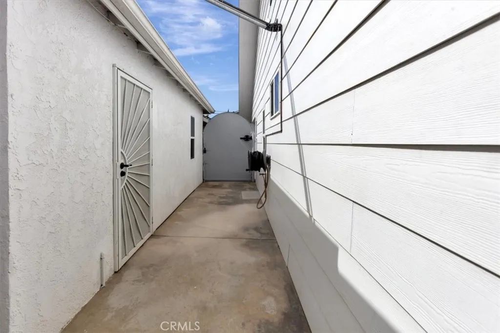 West gate from front to side with door access to garage, currently used as flex guest space and overflow storage. Can be reverted to 2-car garage space. Space also includes an interior side-by-side laundry and utility sink and three-quarter bath. Owners used this space as a studio en suite when they rebuilt the original home. This area is not included in living space or bath count. All work done in workmanlike manner by licensed contractors. Area has mini split Air Conditioning and Heating. See additiona...