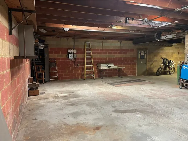 Concrete block walls for sound proofing. Looking inside from L-shaped area that leads to man door at rear behind this spot. 1,200 SF permitted working and storage space known as a "Hobby Garage" -- essentially an auxiliary garage.