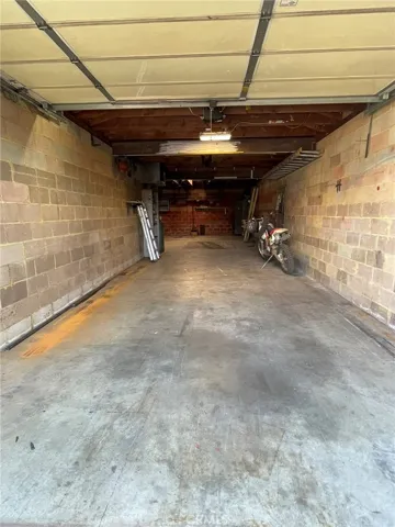 From front garage door at front towards rear wall and further room expanding to the left at the end.