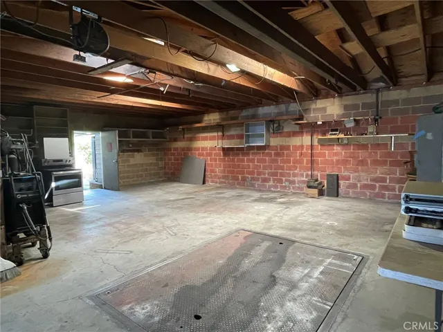 From inside towards rear man garage door to rear patio and veranda. In-floor lift table for work table and was used limited ways for vehicle lift by owner.