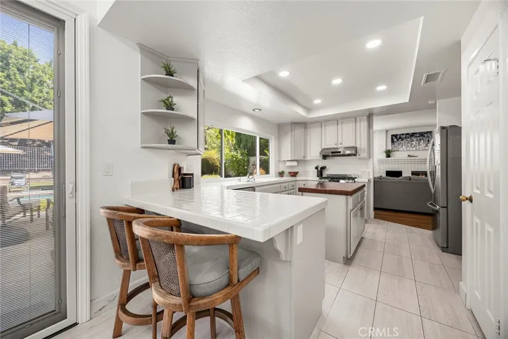 Seating at the island peninsula is a perch for conversations and homework questions while the chef is cooking. The door on the right is a walk-in pantry, perfect for Costco or Sam’s Club shopping trips.