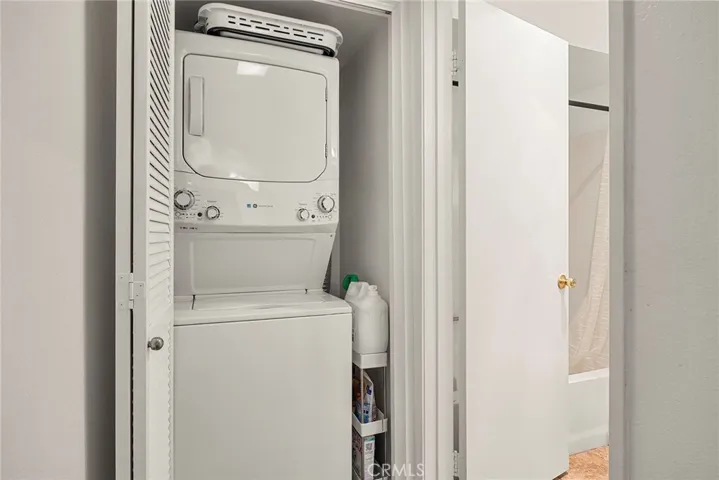 Convenient indoor stackable laundry with included appliances, tucked behind shutter doors for a clean, concealed look when not in use.