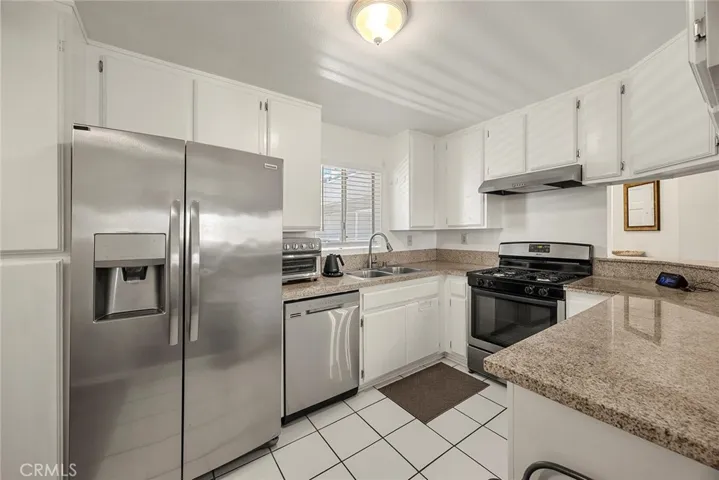 Bright kitchen with ample cabinet storage, generous counter space, and stainless steel appliances.