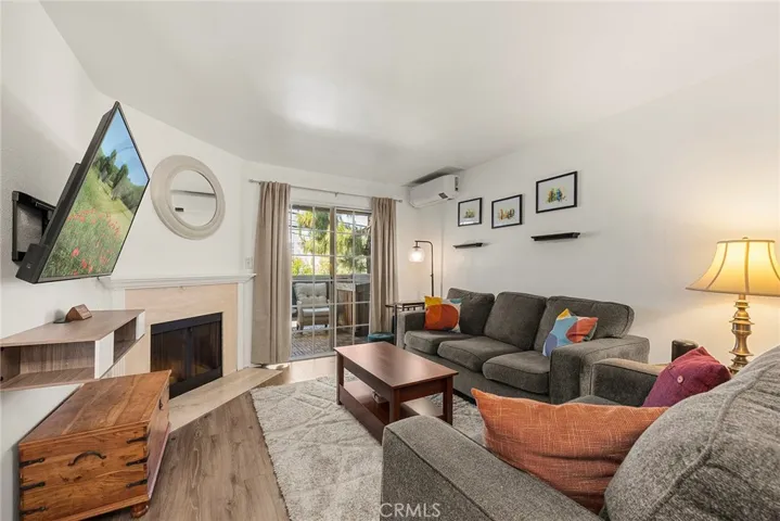 Living room featuring a cozy fireplace and sliding glass door to the private patio, perfect for morning coffee or unwinding while enjoying the ocean breeze.