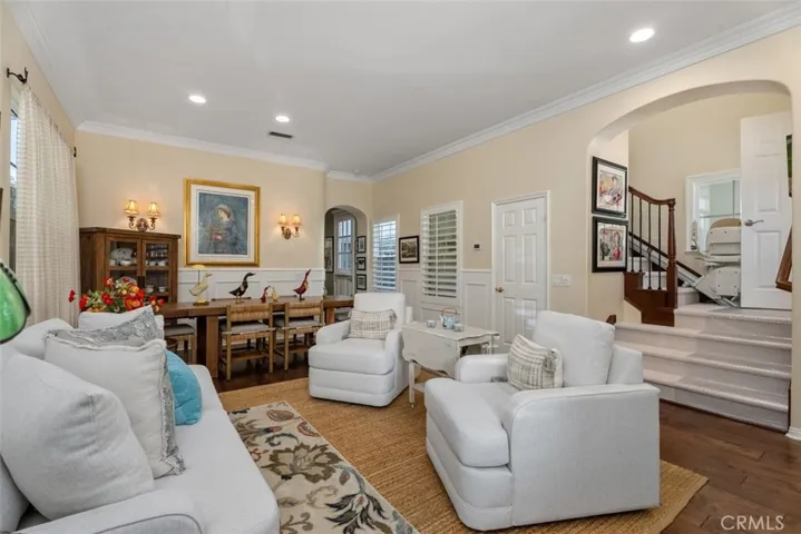 Living Room/Dining Room Combination with Rich Wood Floors, Wainscoting and Crown Molding.