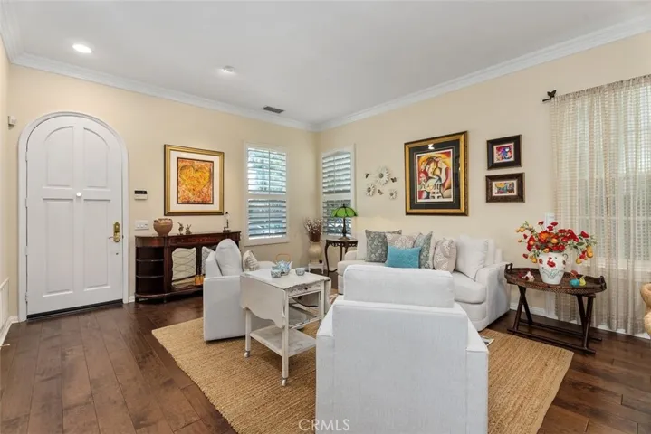 Living Room/Dining Room Combination with Rich Wood Floors, Wainscoting and Crown Molding.