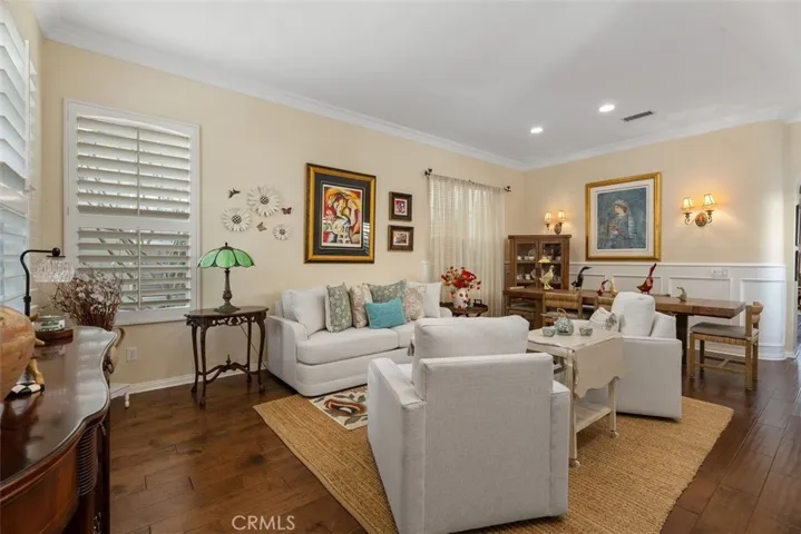 Living Room/Dining Room Combination with Rich Wood Floors, Wainscoting and Crown Molding.