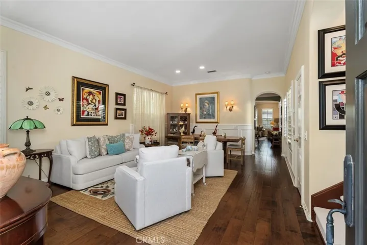Living Room/Dining Room Combination with Rich Wood Floors, Wainscoting and Crown Molding.