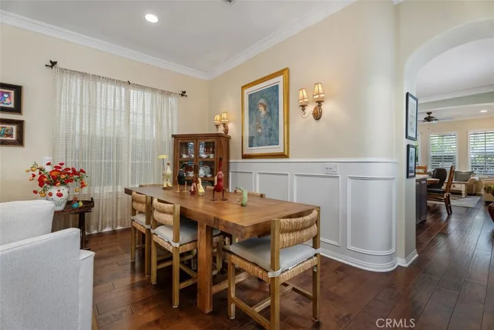 Living Room/Dining Room Combination with Rich Wood Floors, Wainscoting and Crown Molding.