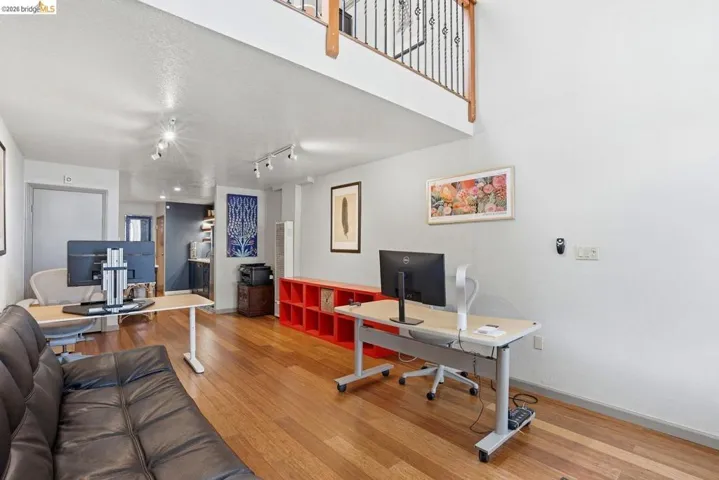 Spacious interior featuring wood-finish flooring, high ceilings, and track lighting