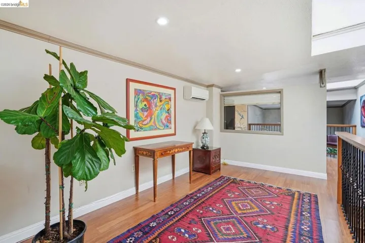 Hallway featuring wood-finish flooring, recessed lighting, and a wall-mounted mini-split system