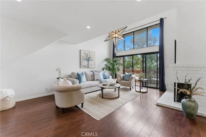 spacious living room with floor to ceiling windows and slider and fireplace