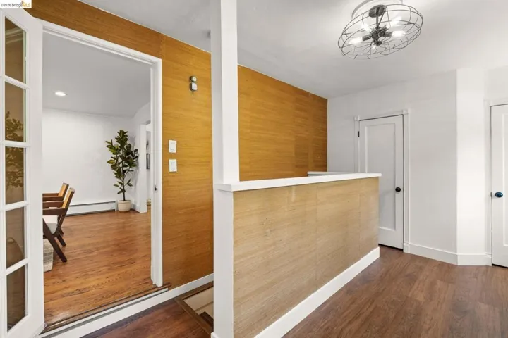 Entryway featuring wood-finish flooring, textured wall coverings, and a contemporary flush-mount ceiling light fixture
