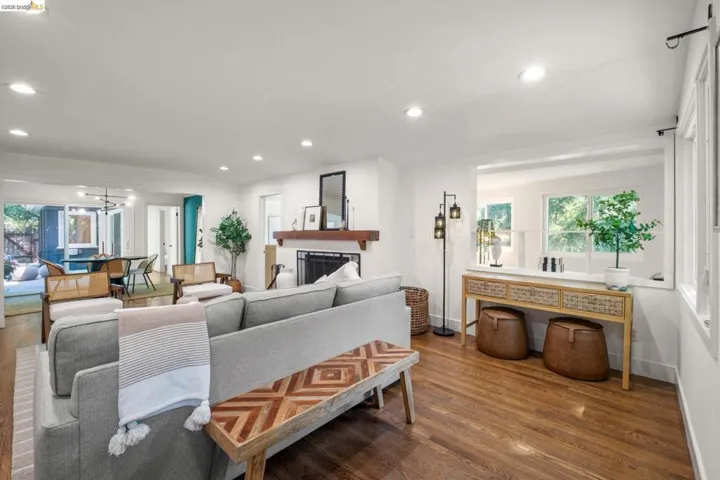 Living area with wood-finish flooring, recessed lighting, and a prominent fireplace featuring a wood mantel