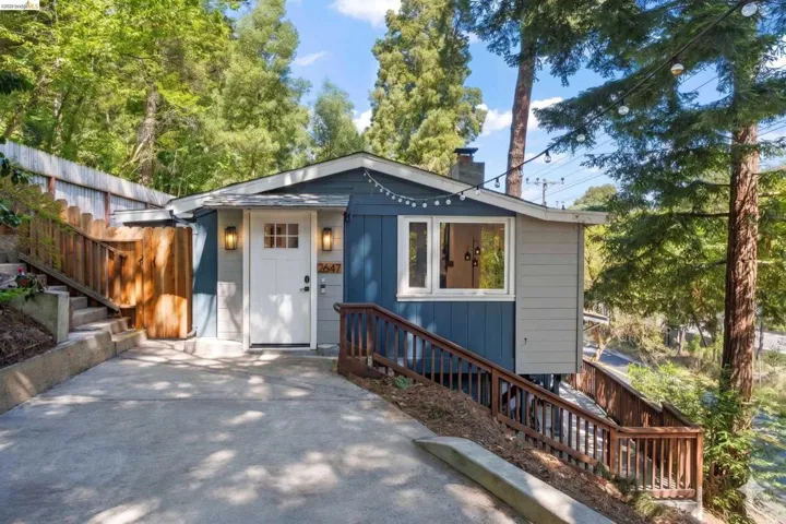 Modern exterior with two-tone siding, a white entry door, and a concrete driveway