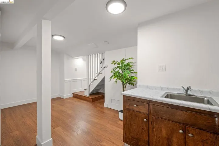 Lower level space featuring wood-finish flooring, white walls, recessed ceiling lights, and wainscoting details