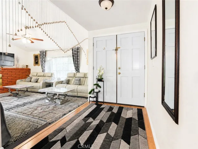 Welcoming entryway opening into the main living room and fireplace area.