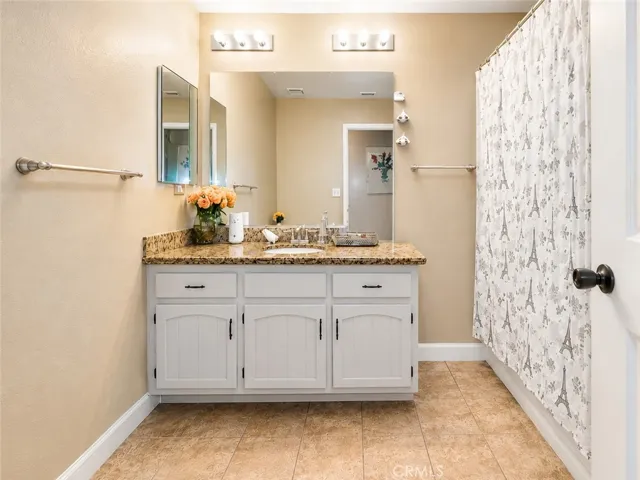 Spacious bathroom with granite counters, extra vanity space, and clean updated finishes.
