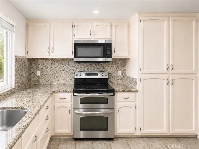 Updated kitchen with granite counters, stainless appliances, and ample cabinetry.