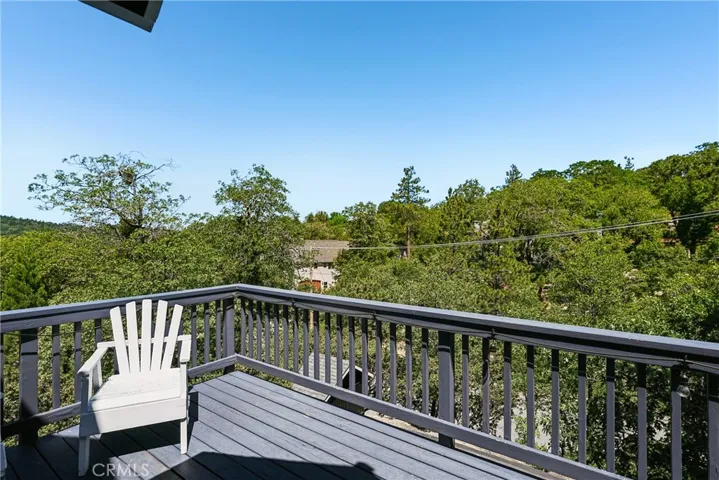 Natural mountain yard with mature trees, boulders, native landscaping, and outdoor space that reflects the relaxed Lake Arrowhead lifestyle.