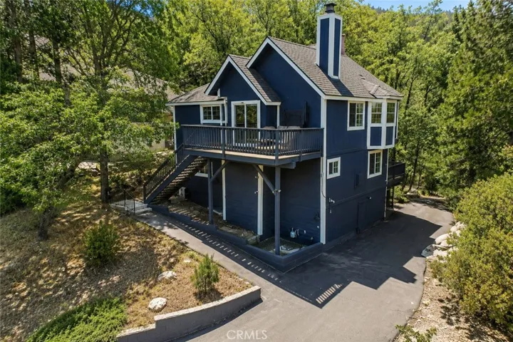 Mountain home in Lake Arrowhead with Lake Arrowhead lake rights, generous driveway space, elevated deck living, and a peaceful treed setting near local trails and recreation.