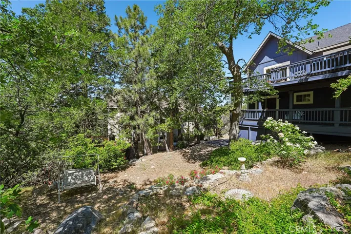 Landscaped and usable mountain yard with mature trees, natural boulders, open outdoor space, and room to enjoy the Lake Arrowhead lifestyle, an uncommon find.