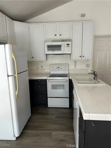 Kitchen open to living area with stove, fridge microwave and dishwasher