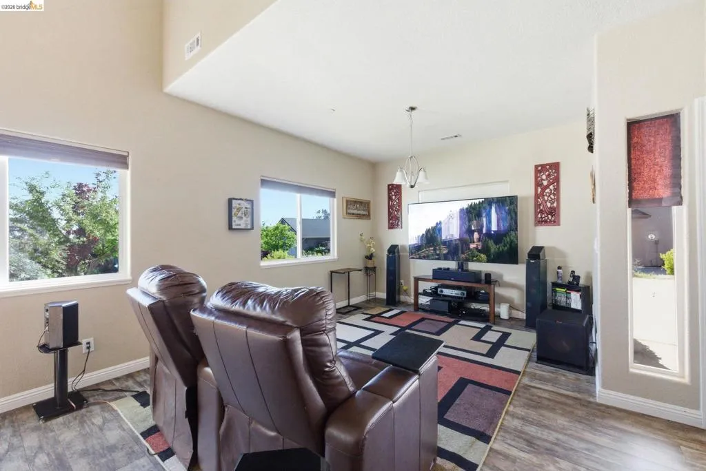 Living area featuring wood finished floors and suspended lighting