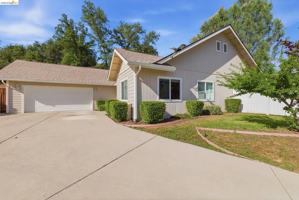 View of front facade with an attached garage, driveway, and roof with shingles