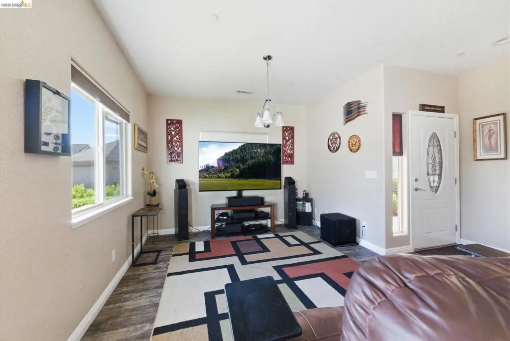 Living room featuring baseboards and dark wood-style floors