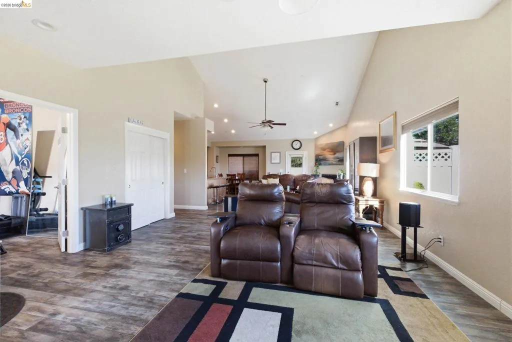 Living room featuring vaulted ceiling, wood finished floors, ceiling fan, and recessed lighting