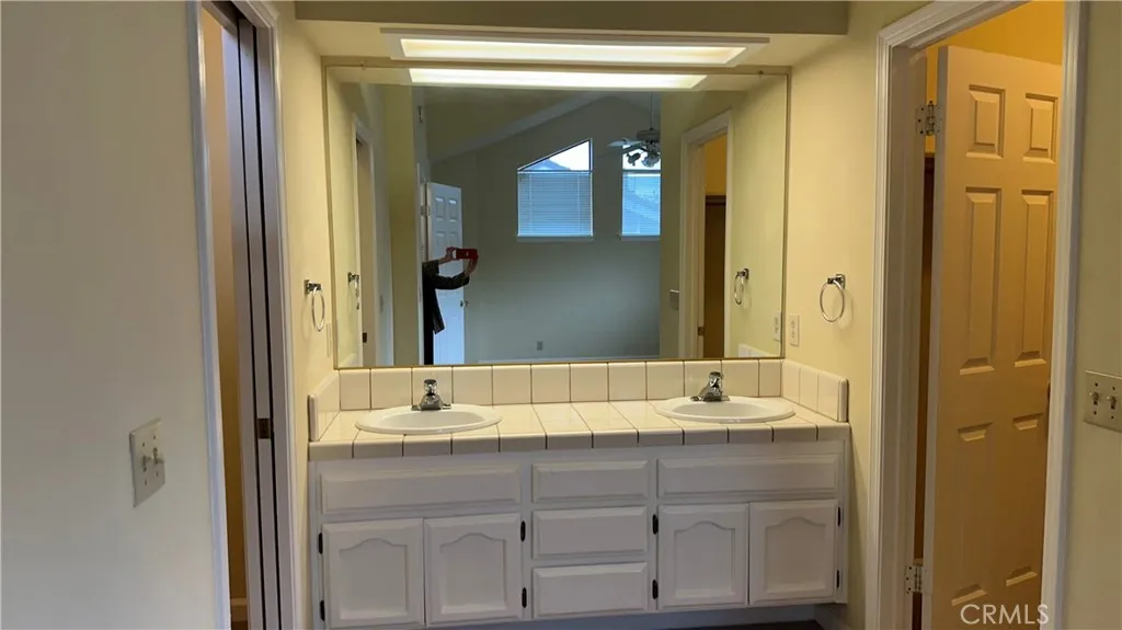 Primary bathroom dual sink, plus shower and toilet area not shown.