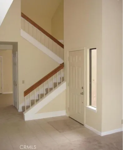 Staircase going up to the two bedrooms, at each end of the home. Primary bedroom room and 2nd bedroom.