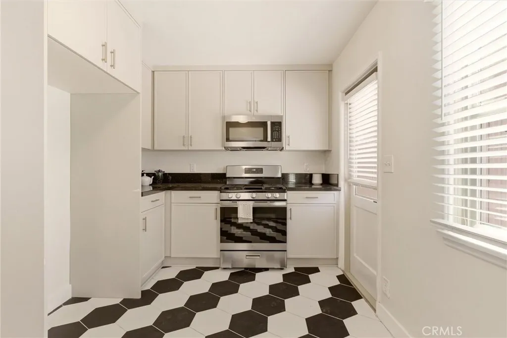 Completely reimagined, the kitchen features custom cabinetry, quartz countertops, stainless steel appliances, and modern finishes.