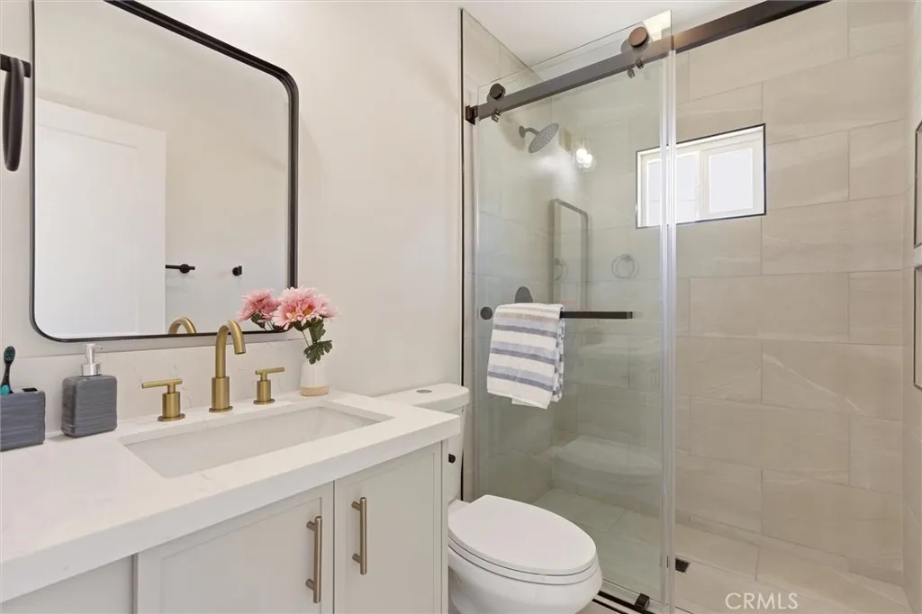 The newly added en-suite bathroom elevates the home with a spacious walk-in shower, custom tile work, and elegant glass enclosure for a clean modern feel.